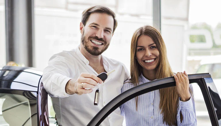 Pareja disfrutando de su auto nuevo