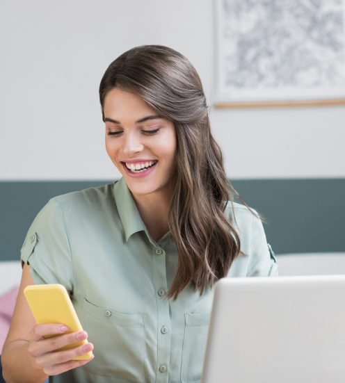 Mujer sonriendo mientras mira su teléfono